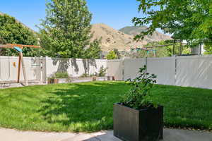 View of yard featuring a garden, a fenced backyard, and a mountain view