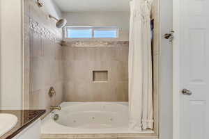 Full bath with a combined bath / shower with jetted tub and vanity