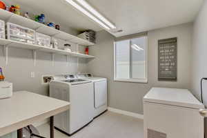 Laundry area featuring laundry area, baseboards, visible vents, washing machine and clothes dryer, and a textured ceiling