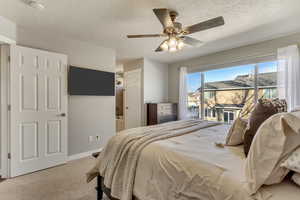 Bedroom with carpet floors, ceiling fan, a textured ceiling, access to outside, and baseboards