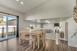 Dining space with lofted ceiling, baseboards, wood finished floors, and recessed lighting