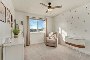 Living area featuring ceiling fan, visible vents, baseboards, and light colored carpet