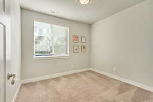 Unfurnished room featuring light carpet, visible vents, and baseboards