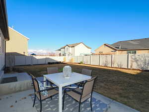 View of patio with outdoor dining area and a fenced backyard