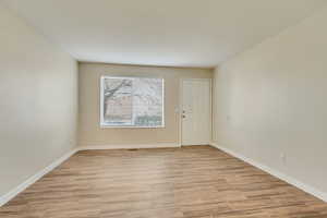 Spare room featuring baseboards and wood tiled floor