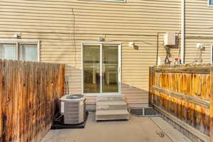 Exterior space with entry steps, central AC, and fence