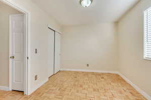 Unfurnished bedroom with multiple windows and baseboards