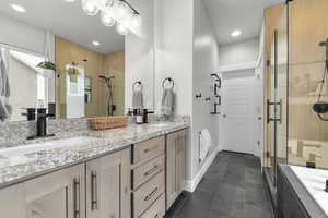 Primary Bathroom featuring vanity, tile patterned flooring, and a shower with shower door