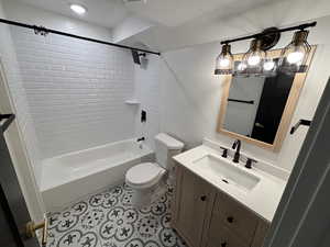 Bathroom featuring shower / washtub combination, toilet, a textured ceiling, vanity, and tile patterned flooring