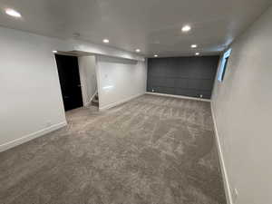 Finished below grade area with baseboards, stairway, carpet, and recessed lighting