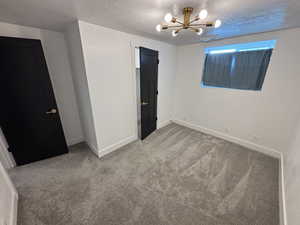 Unfurnished bedroom with baseboards, carpet flooring, visible vents, and a textured ceiling