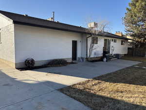 Back of property with entry steps, a lawn, a patio, fence, and brick siding