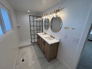 Full bathroom featuring marble finish floor, visible vents, a sink, and baseboards