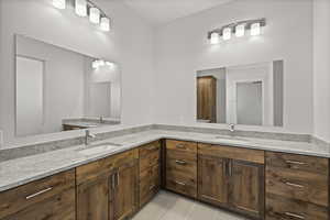Primary bathroom with double vanity, a sink, and tile patterned floors