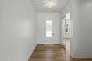 Foyer with glass entry door and laminate floors