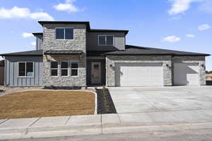 Prairie-style house featuring a garage, a front lawn, board and batten siding, and concrete driveway