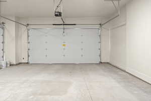 Garage with a garage door opener and baseboards