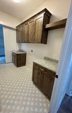 Laundry room with a sink, cabinet space, washer hookup, and entry to Primary bedroom closet