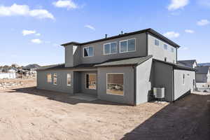 Back of property with central AC unit, roof with shingles, a residential view, and stucco siding