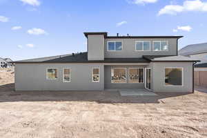 Back of property featuring roof with shingles, a patio, and stucco siding