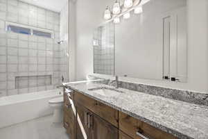 Main level full bathroom featuring tile patterned flooring, bathtub / shower combination, vanity, and toilet