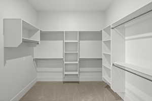 Primary walk-in closet with entry to laundry room