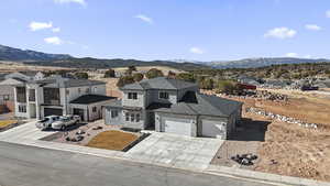 View of front of house with stone siding, a residential view, and a mountain view