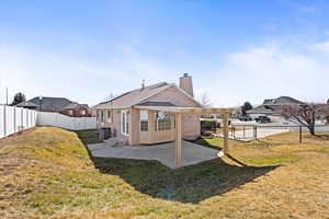 Rear view of property with brick siding, a patio, a chimney, a lawn, and a fenced backyard