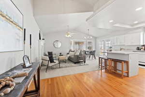 Living area featuring vaulted ceiling, recessed lighting, a ceiling fan, and light wood-style floors