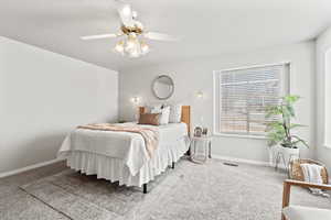 Carpeted bedroom featuring visible vents, baseboards, and a ceiling fan