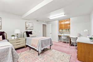 Bedroom with built in desk, carpet, visible vents, and baseboards