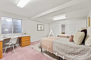 Carpeted bedroom with baseboards and multiple closets