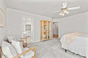 Bedroom featuring baseboards, ceiling fan, ensuite bathroom, and light colored carpet