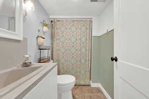 Bathroom with visible vents, toilet, a shower with curtain, tile patterned floors, and vanity