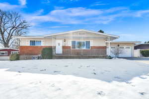 Ranch-style home with an attached garage, brick siding, and a porch