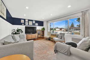 Living area featuring recessed lighting, a wainscoted wall, and wood finished floors