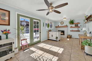 Living room with plenty of natural light, a fireplace, ornamental molding, and light tile patterned flooring