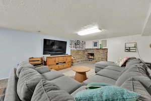 Living area with carpet, a fireplace, visible vents, and a textured ceiling