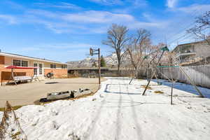 Yard covered in snow featuring fence