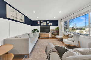 Living area featuring recessed lighting, wainscoting, wood finished floors, and a decorative wall