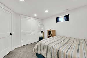 Carpeted bedroom featuring recessed lighting, a closet, and visible vents