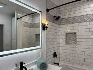 Bathroom with a sink, visible vents, and shower / bath combination with curtain