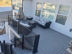 Wooden terrace with an outdoor living space with a fire pit and fence