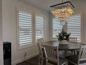 Dining area with baseboards, a chandelier, and dark wood finished floors