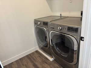 Laundry room with laundry area, baseboards, washing machine and clothes dryer, and wood finished floors