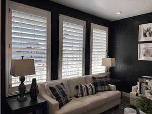 Living area featuring baseboards and a textured ceiling