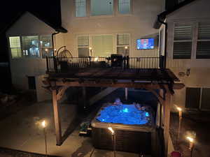 Exterior space with a hot tub and a wooden deck