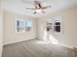 Carpeted empty room featuring crown molding, visible vents, a ceiling fan, a textured ceiling, and baseboards