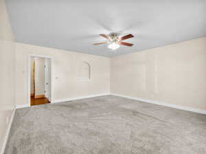 Unfurnished room featuring ceiling fan, baseboards, and carpet flooring