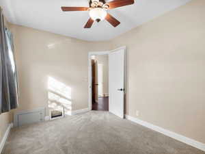 Spare room with carpet, baseboards, and ceiling fan